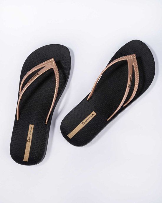 Zwarte Ipanema teenslippers met goudkleurige bandjes met gevlochten detail.