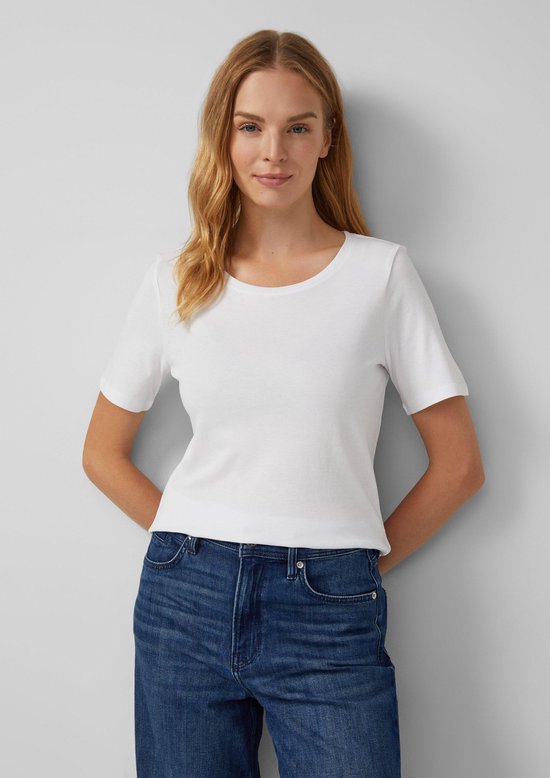 Model in een effen wit s.Oliver T-shirt en een spijkerbroek.