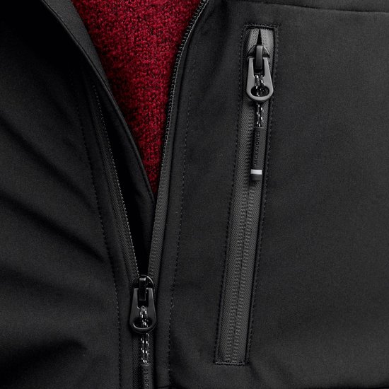 Detail van zwarte jas met ritssluitingen en 'Jack & Jones' op de ritslip.