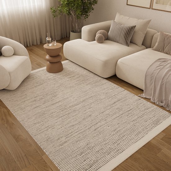 Un tapis crème rayé dans un salon lumineux avec des meubles beiges et un fauteuil.