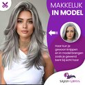 Model met lang, grijs gestyled haar, met lokken en lagen. Een cirkelvormige inzet toont het begin van de pruik.