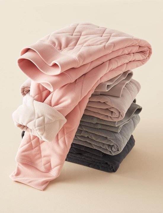 Stapel gewatteerde thermobroeken in roze, lichtpaars, grijs en antraciet, met 'FASHION' ingeweven in de stof.