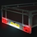 Trailer achterkant met een kentekenplaatverlichting die de gele plaat verlicht.