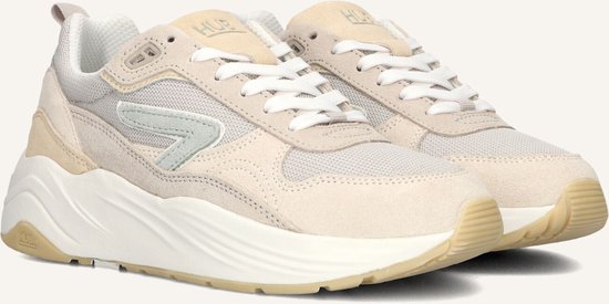 Close-up van beige suède en mesh sneakers met dikke witte zolen en lichtgroen logo.