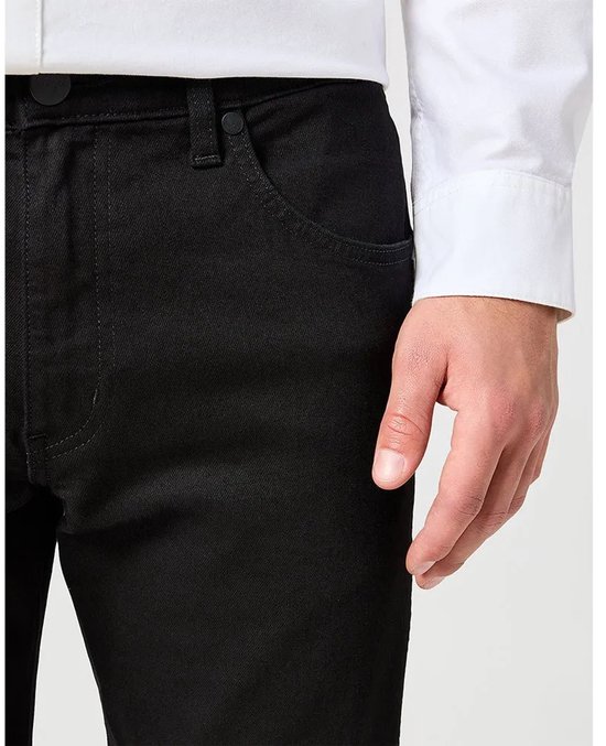Zwarte jeans, close-up van de voorkant met zakken en een knoop.