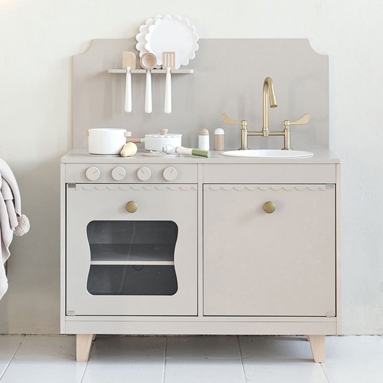 Houten speelkeuken in zachtgrijs met gouden kranen en knoppen. Keukentje heeft een oven met glazen deur en opbergvakken.