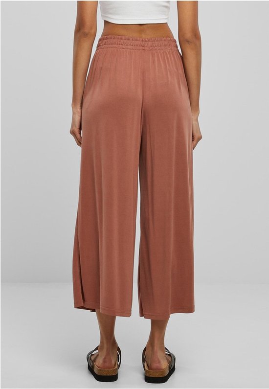 Achterzicht van bruine culotte met elastische tailleband en wijde pijpen, op model.