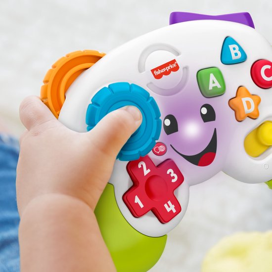 Kind hand draait blauwe knop op Fisher-Price controller met A, B, C, D knoppen, 1-4 cijfers en lichtjes.