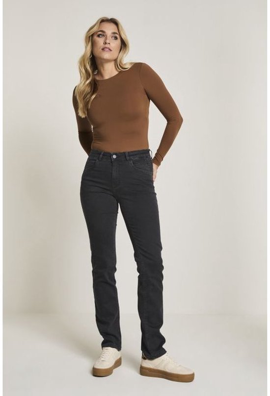 Model draagt een donkergrijze straight leg jeans en een bruine longsleeve.