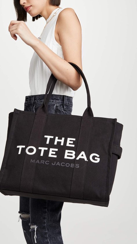 Vrouw met zwarte canvas tas van Marc Jacobs met opdruk "THE TOTE BAG MARC JACOBS".