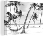 Canvas Schilderij Hangmat tussen palmbomen op het strand bij de Dominicaanse Republiek - zwart wit - 120x80 cm - Wanddecoratie