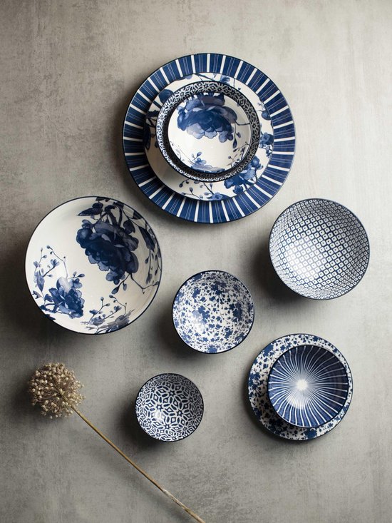 Een collectie blauw-witte serviesstukken met verschillende patronen, waaronder bloemen, strepen en geometrische vormen.
