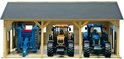 Houten landbouwloods met een blauwe landbouwmachine, oranje tractor en blauwe tractor.