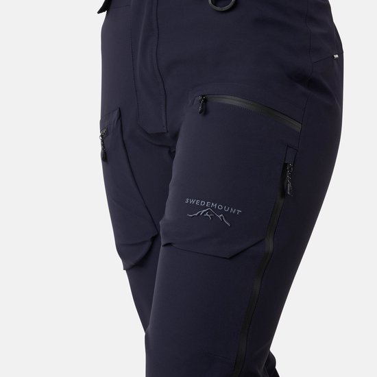 Detail van donkerblauwe skibroek met twee opgestikte zakken en het 'SWEDEMOUNT' logo.