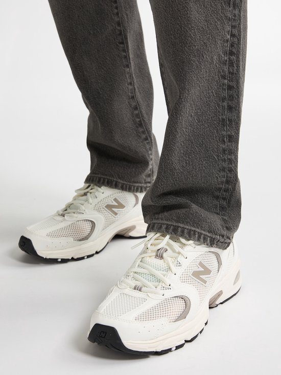 Witte sneakers met beige en grijze accenten en een N-logo.