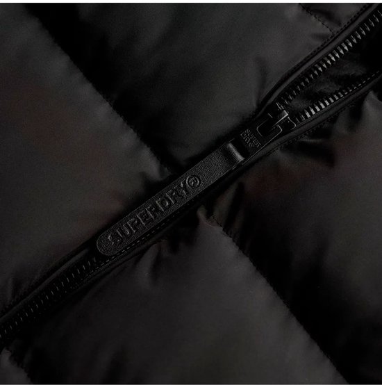 Sluiting met rits en trekker met 'Superdry' logo op een zwarte pufferjas.