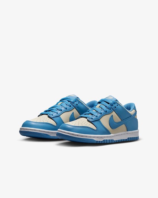 Twee Nike Dunk Low sneakers in crème en lichtblauw leer met blauwe veters, gezien vanaf de voorkant.