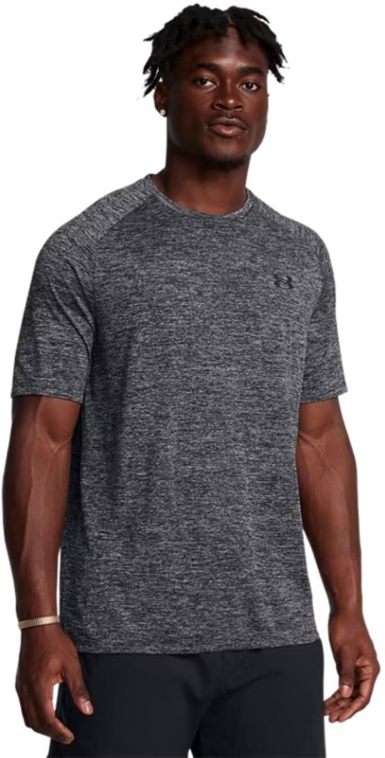 Man met een zwart gemêleerd sportshirt met korte mouwen en een zwarte broek.