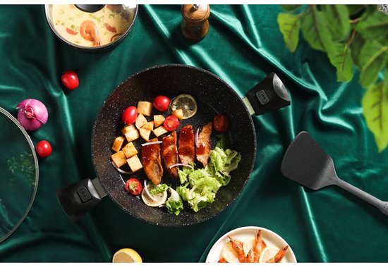 Une poêle noire avec des saucisses grillées, des légumes et du citron.