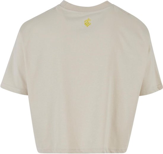 Crèmekleurige crop top, achterkant met een klein geel logo.