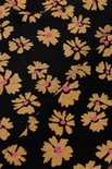 Close-up van zwart textiel met all-over print van gele bloemen met roze hartjes.