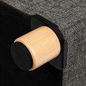 Detail van een houten pootje met zwarte bescherming onderaan de grijze stoffen poef.