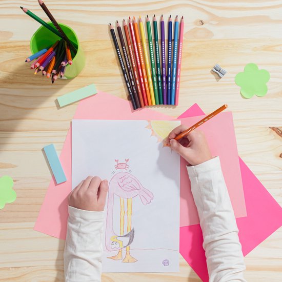 Kind tekent met oranje potlood op papier met flamingo en struisvogel.