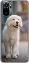 Geschikt voor Xiaomi Redmi Note 10 hoesje - Een Golden Retriever puppy lopend op de stoep - Siliconen Telefoonhoesje
