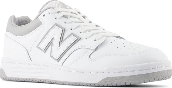 Witte lage sneaker van New Balance met grijze accenten en een groot grijs 'N' logo op de zijkant.