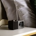 Zwarte Lenco wekkerradio met antenne, deels zichtbaar op een nachtkastje.