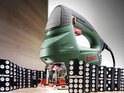 Groene Bosch decoupeerzaag met PowerLight en 'Low Vibration' naast domino's.