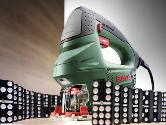 Groene Bosch decoupeerzaag met PowerLight en 'Low Vibration' naast domino's.