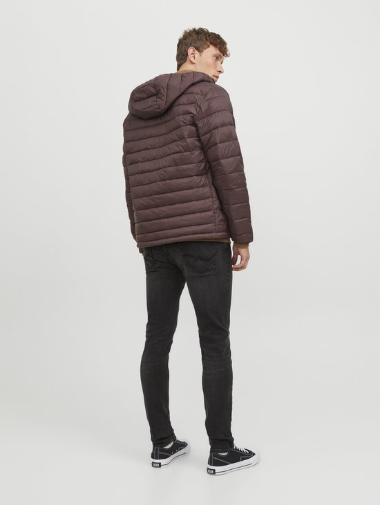 Achteraanzicht van een man in donkerbruine pufferjas, bruine trui en donkergrijze jeans.