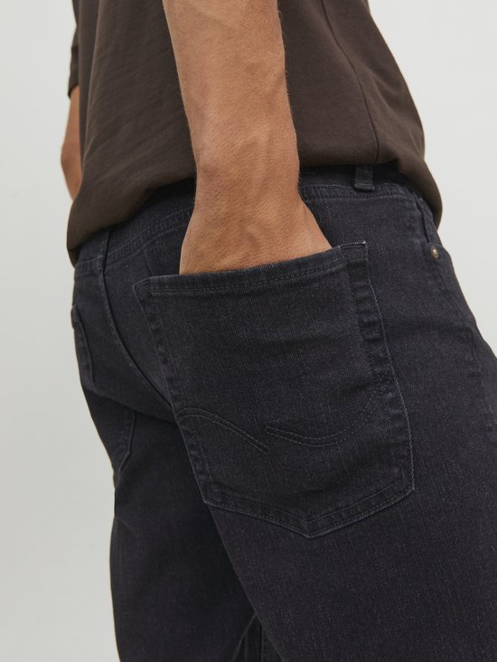 Achterkant van de zwarte denim jeans met zakken en stiksels.