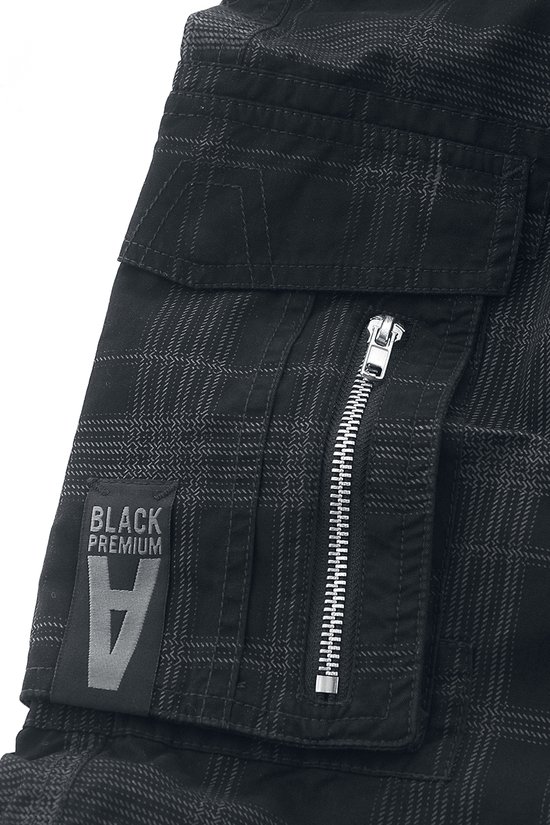Detail van een zwarte cargobroek met ruitjesprint, rits en 'BLACK PREMIUM' label.