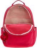 Sac à dos Kipling rouge ouvert avec doublure rose, des tons beiges et un porte-clés singe rouge.