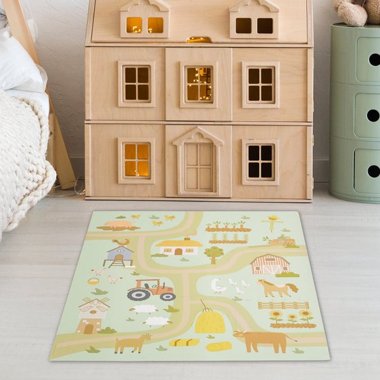 Een grote boerderij speelmat op de vloer van een kinderkamer, naast een bed en poppenhuis.