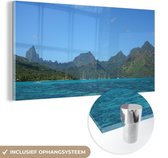 MuchoWow® Glasschilderij 40x20 cm - Schilderij acrylglas - De 'Ōpūnohu baai in Moorea met een bergachtige achtergrond - Foto op glas - Schilderijen