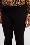 Zwarte legging met een kleine witte ster applicatie op de tailleband, gedragen onder een luipaardprint jurk.