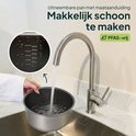 Vrouw spoelt een uitneembare pan van een rijstkoker af onder een kraan, met zicht op maatstreepjes.