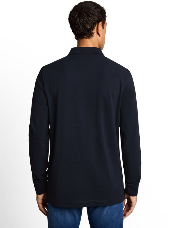 Man van achteren gezien, draagt een donkerblauw poloshirt met lange mouwen.