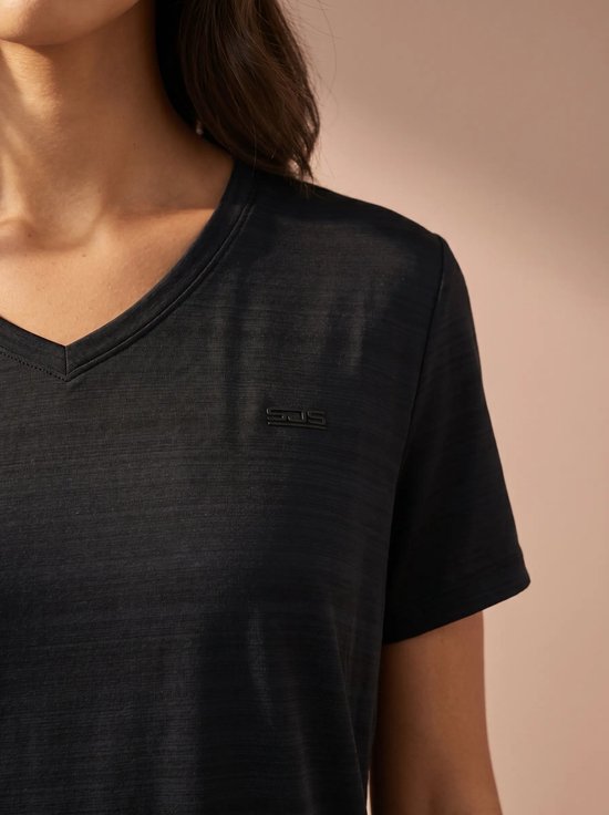 Close-up van een donkerblauw sportshirt met V-hals en een klein logo op de borst.