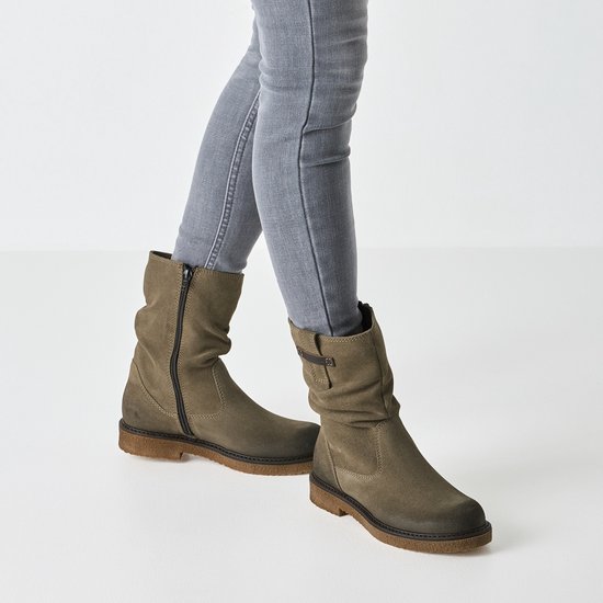 Grijze suède enkellaarsjes met rits en gespdetail, gedragen met grijze jeans.