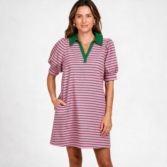 Mannequin les mains dans les poches, portant une robe polo rayée rose et vert foncé.