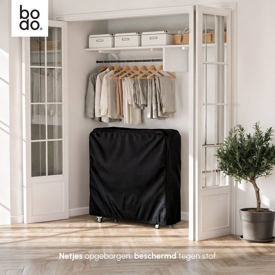 Bodo opvouwbaar bed in zwarte beschermhoes, opgeborgen in een kast. De hoes beschermt tegen stof.