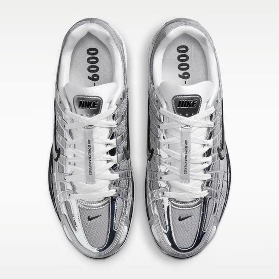 Grijze Nike P-6000 sneakers met zwarte details en witte veters. De zool is wit en zwart. Binnenkant met '0009-'.