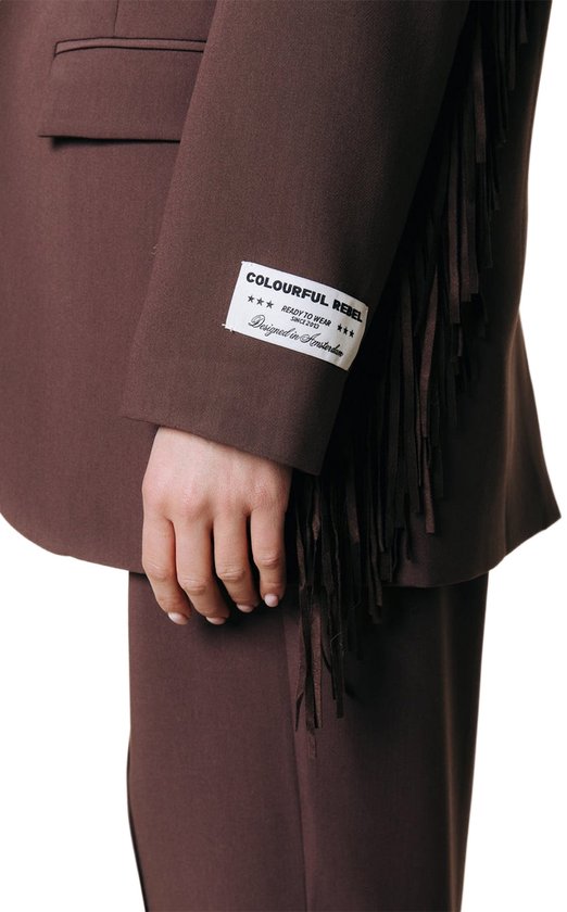 Detail van een bruine blazer met franjes en een label op de mouw. 'COLOURFUL REBEL'.