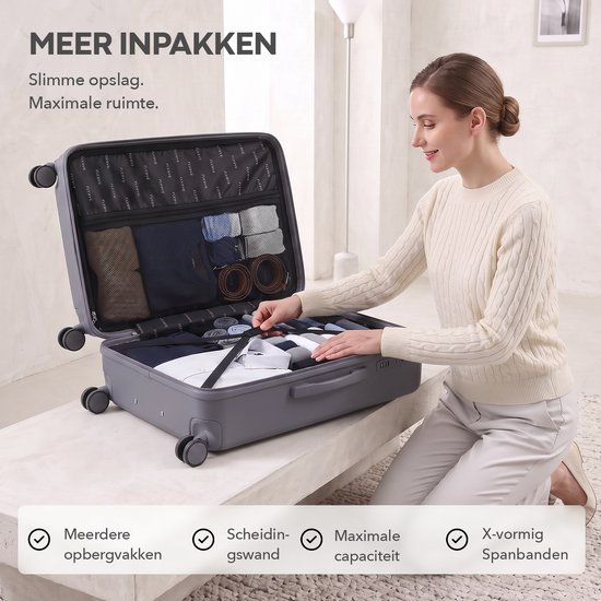 Vrouw pakt een open antracietkleurige koffer in, met interne vakken en spanbanden, in een lichte woonkamer.