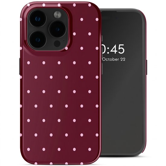 Coque de téléphone bordeaux à pois rose pâle, à côté d'un iPhone.