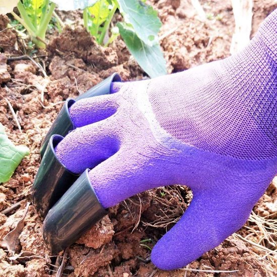 Detail van een paarse tuinhandschoen met zwarte klauwen, in de aarde.